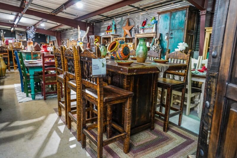 A room with several wooden chairs and tables.