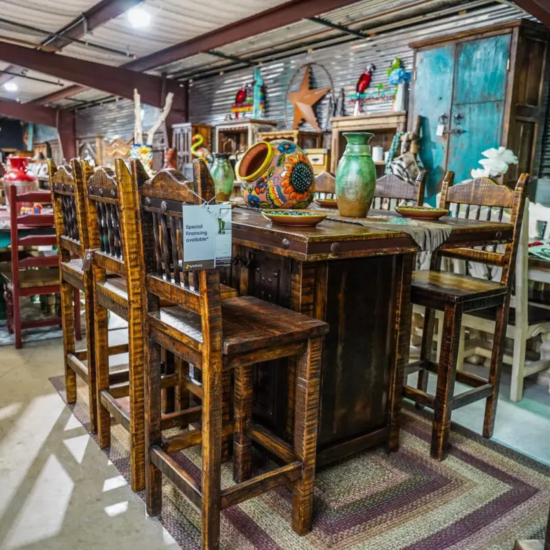 A room with several wooden chairs and tables.