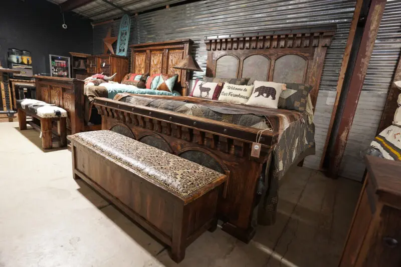 A bed with an animal print pillow and bench.