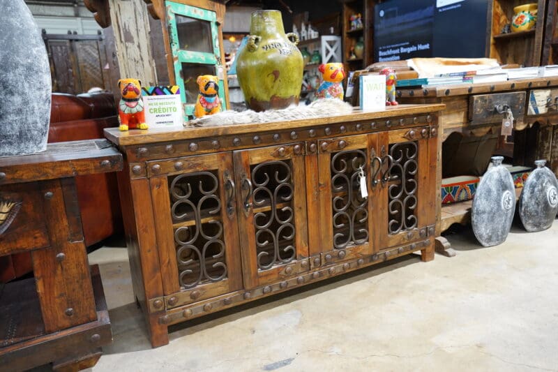 A wooden buffet with metal doors and iron work.