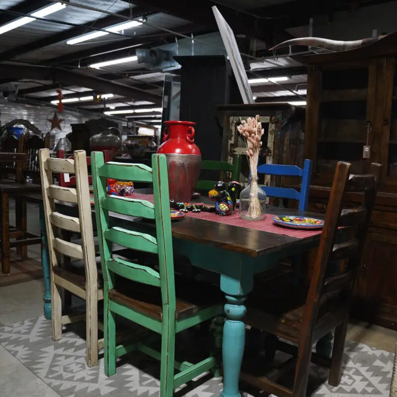 A table with four chairs and a knife on the top of it.