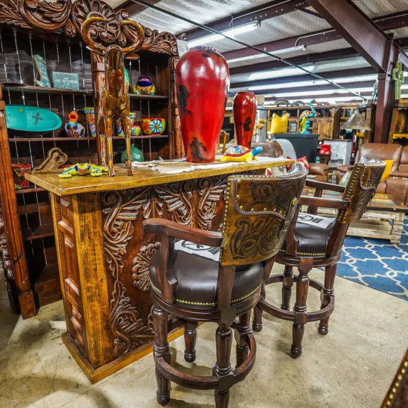 A bar with two chairs and a red fire hydrant.