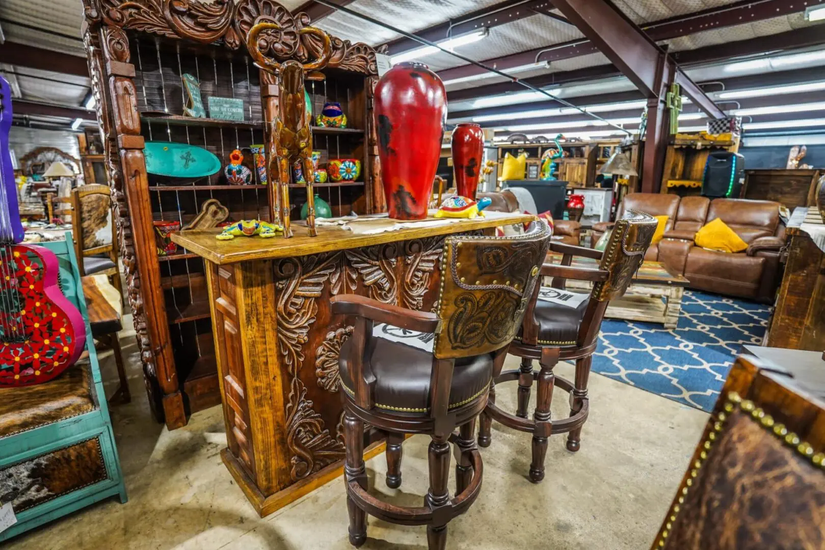 A bar with two chairs and a red fire hydrant.