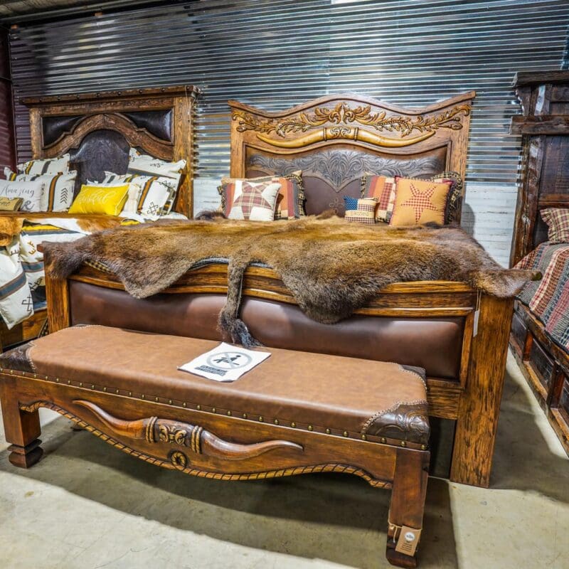 A bed with leather headboard and footstool in the background.