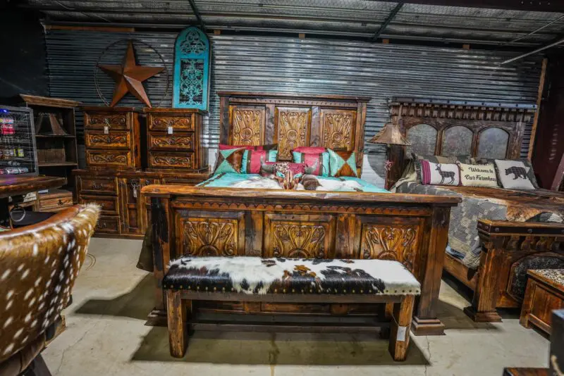 A bed room with a bench and a dresser