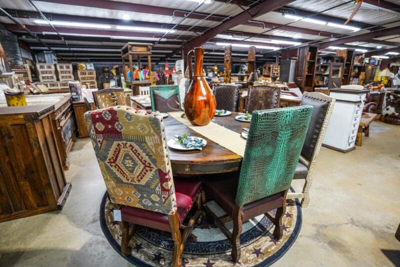 A table with chairs and a vase on top of it.