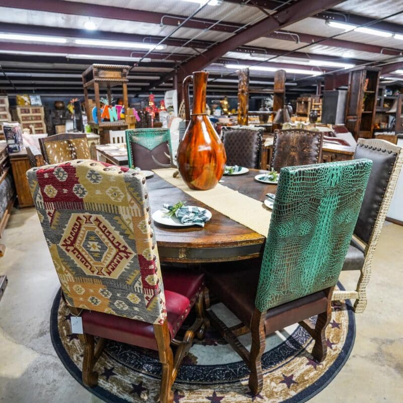 A table with chairs and a vase on top of it.