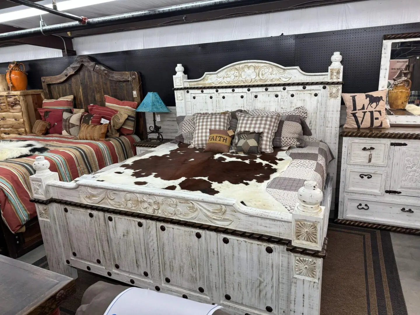 A bed with white wood and brown cow hide.