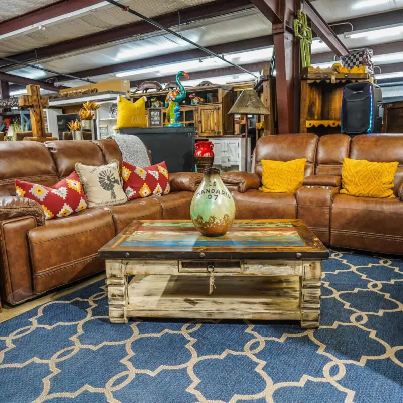 Leather sectional sofa with coffee table and rug.