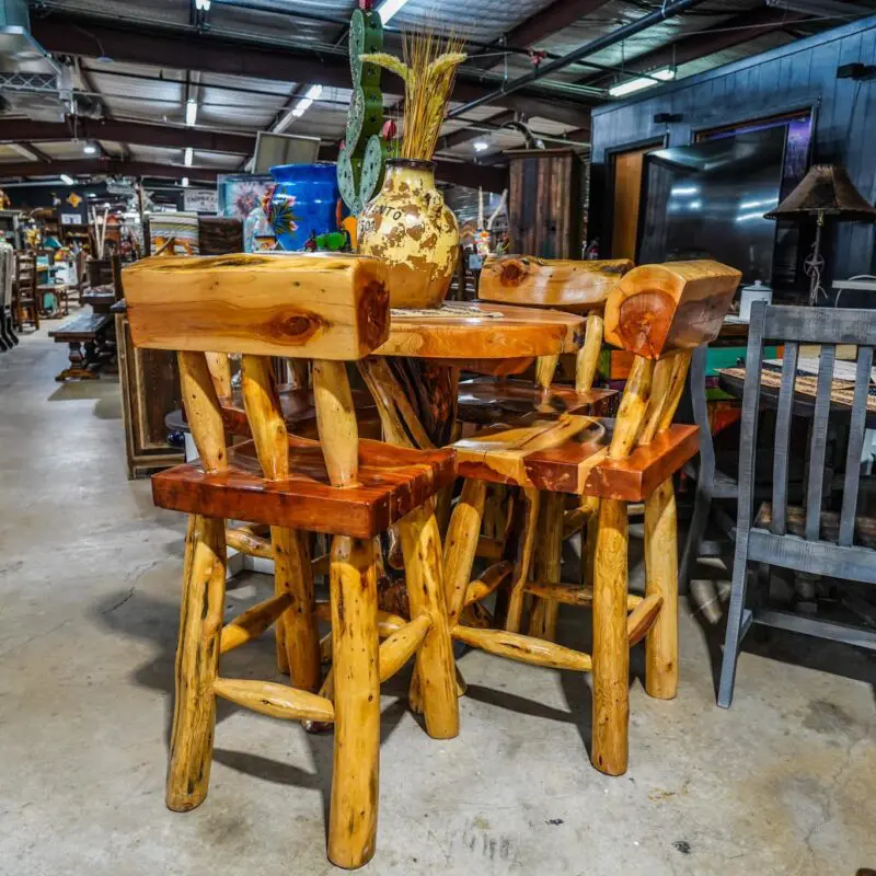 Wooden bar stools and a table in a store.