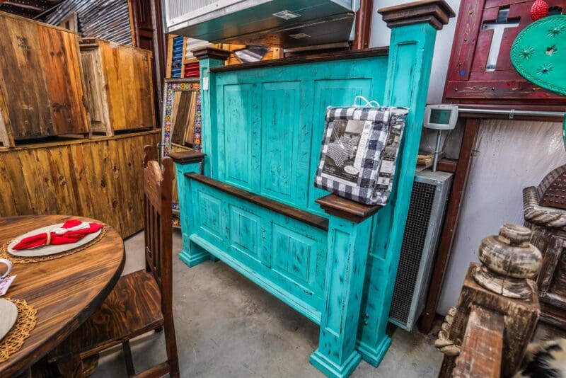 Teal wooden headboard with distressed paint.