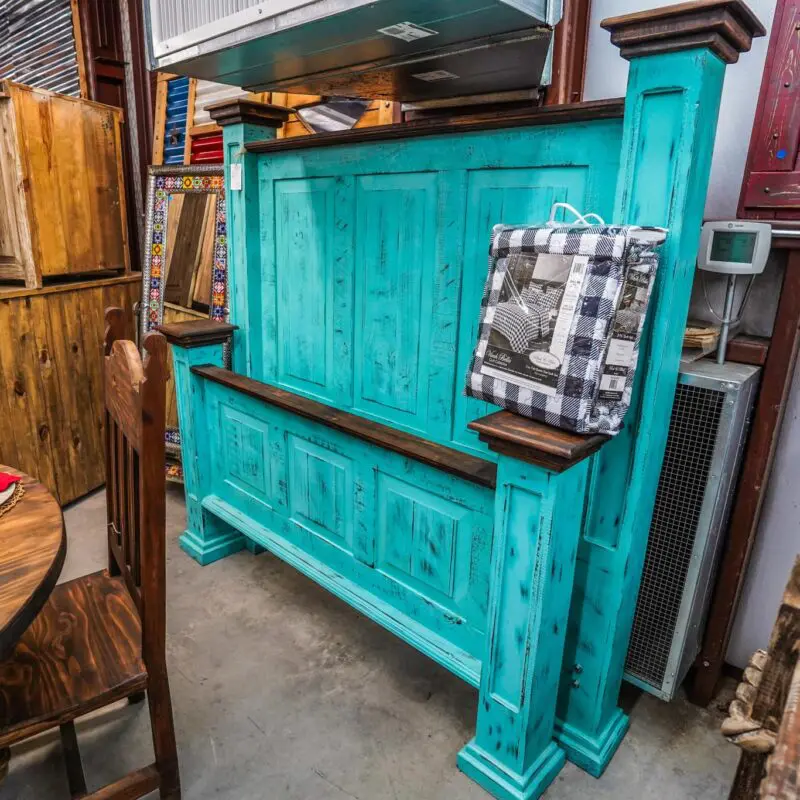 Teal wooden headboard with distressed paint.