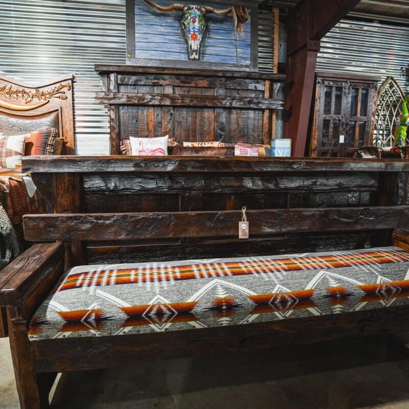 Rustic wooden bench with patterned cushion.