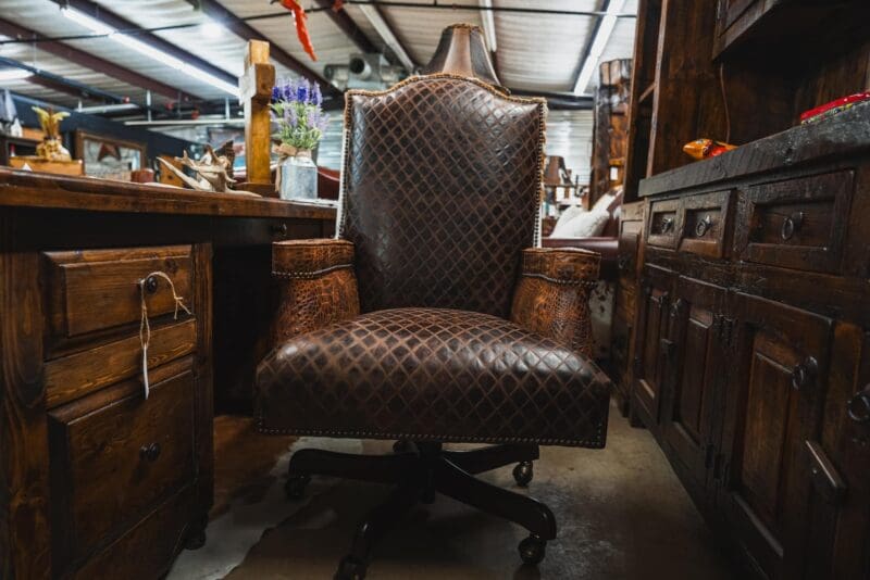 Brown leather office chair with wheels.