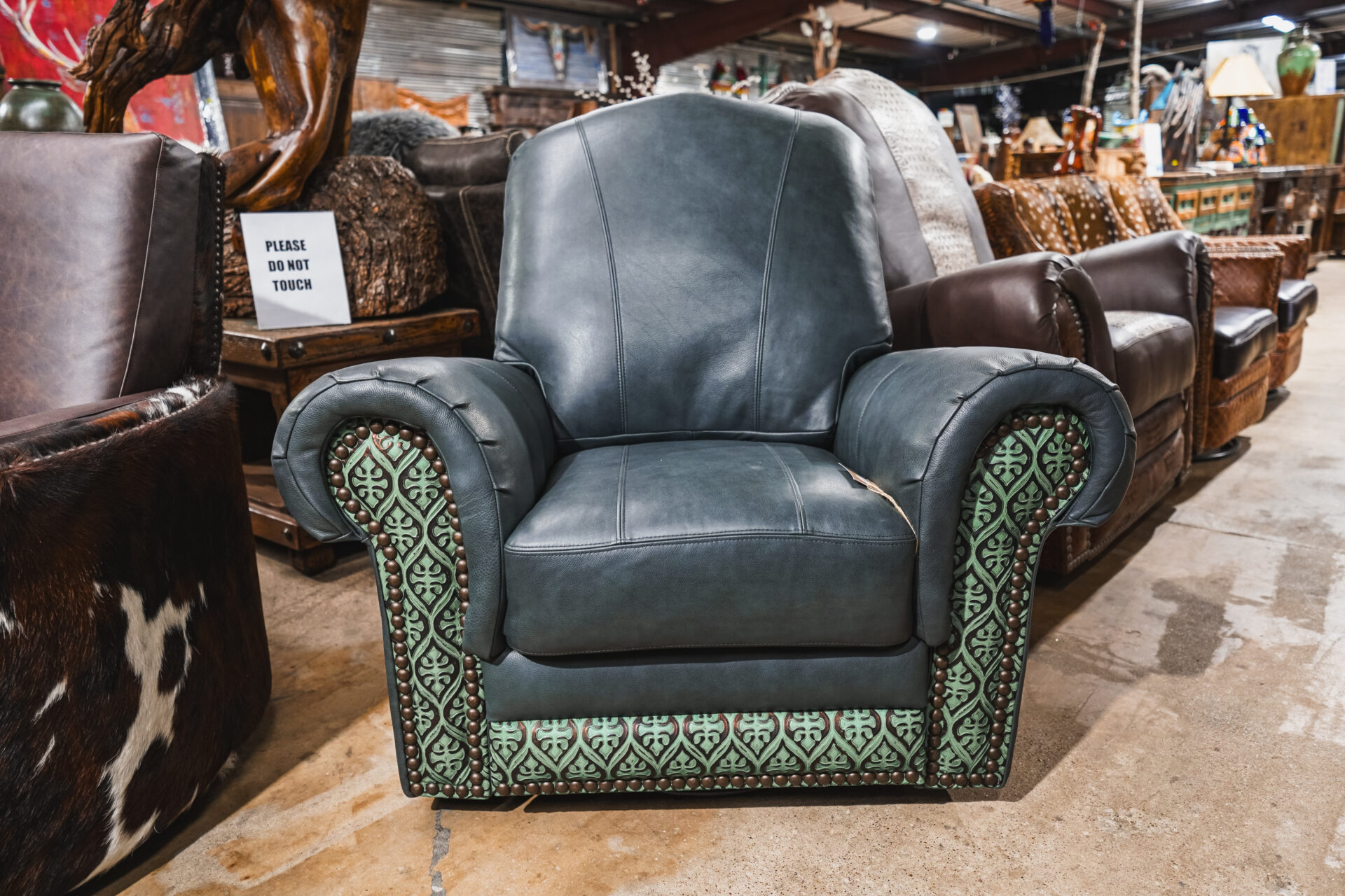 A leather chair with green and blue patterned upholstery.