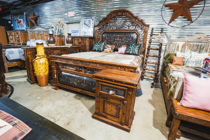 Ornate wooden bed with carved headboard.