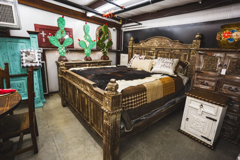 Rustic wooden bed with carved headboard.