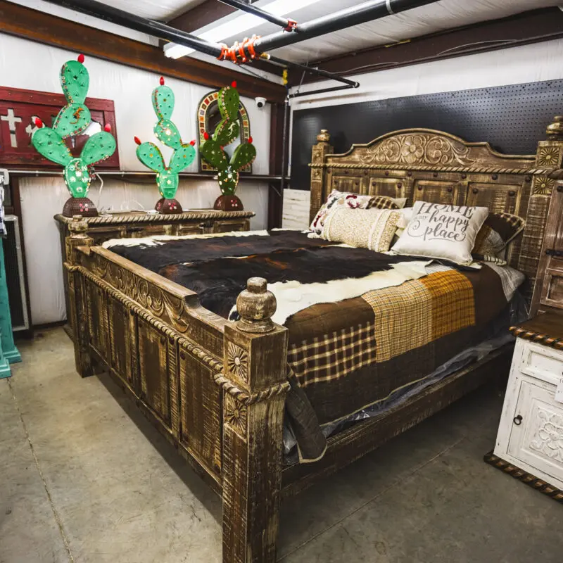 Rustic wooden bed with carved headboard.