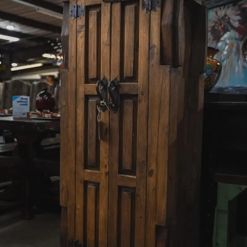 Wooden cabinet with ornate door and hardware.