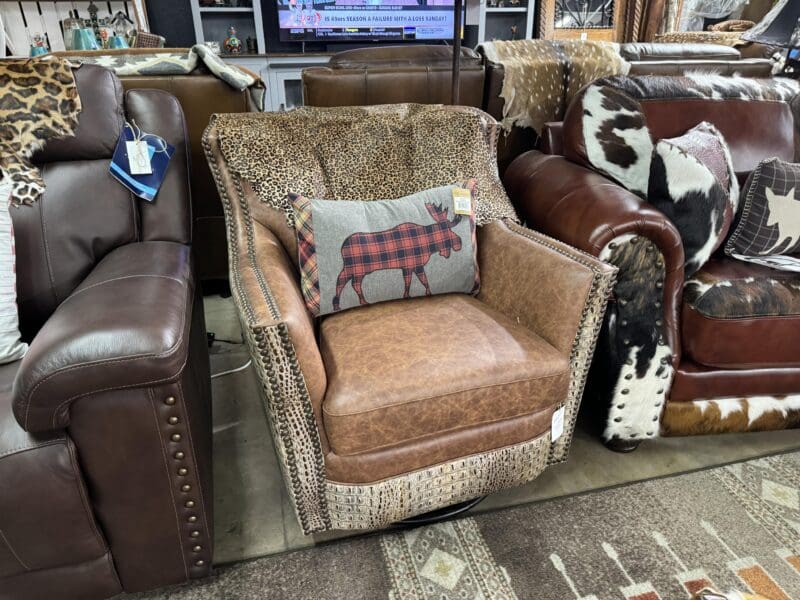 Brown leather armchair with a moose pillow.