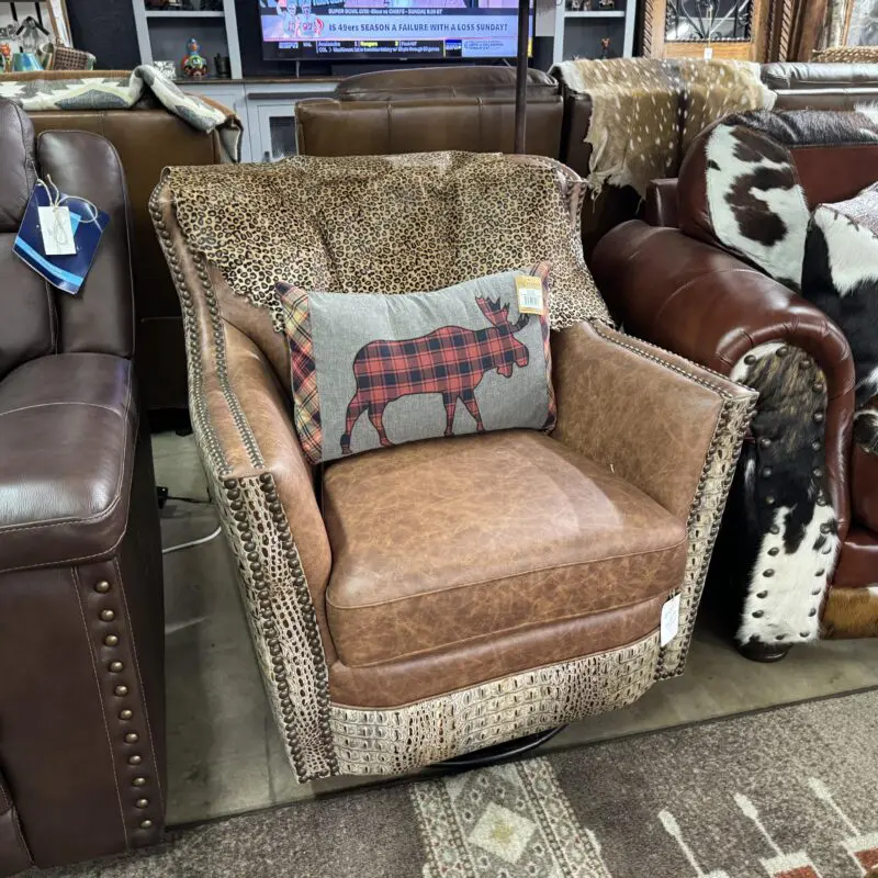 Brown leather armchair with a moose pillow.