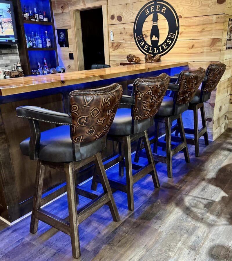 Bar stools with leather seats and blue lighting.