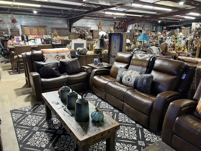 Leather couches with patterned pillows in a store.