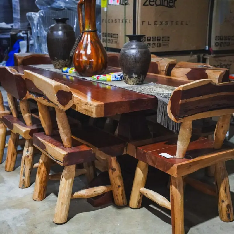 Wooden dining table with chairs and vases.