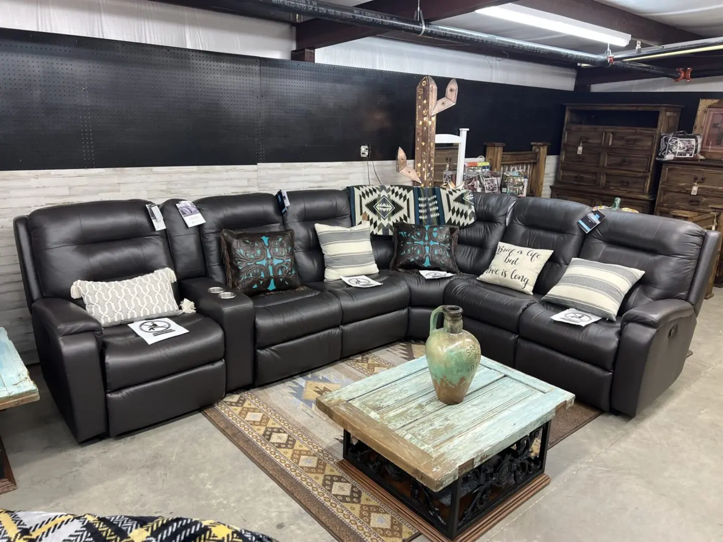 Brown leather sectional sofa with pillows.