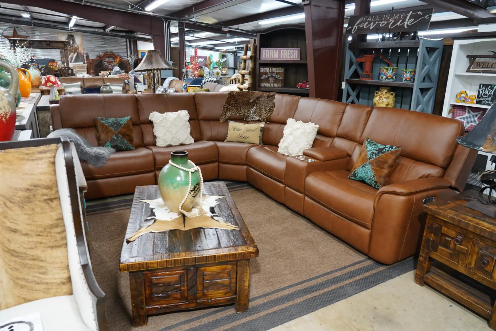 Leather sectional sofa with pillows and coffee table.